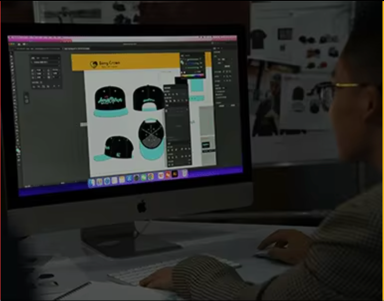The exhibition showcases four design sketches of black embroidered baseball caps from different angles, including side, back, and top-down views.

The brand's designers are using professional software to create digital patterns and print designs for black and turquoise cut-out hats.